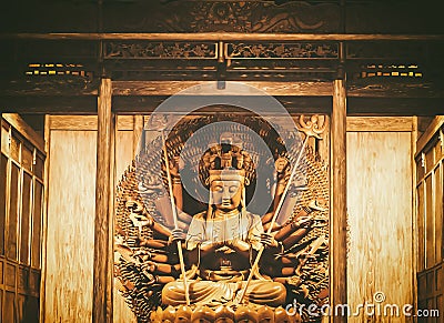 Golden Wood Statue of Guan Yin with thousand hands . Golden sculpture of Avalokiteshvara Buddha or Guanyin with thousand hands in Stock Photo